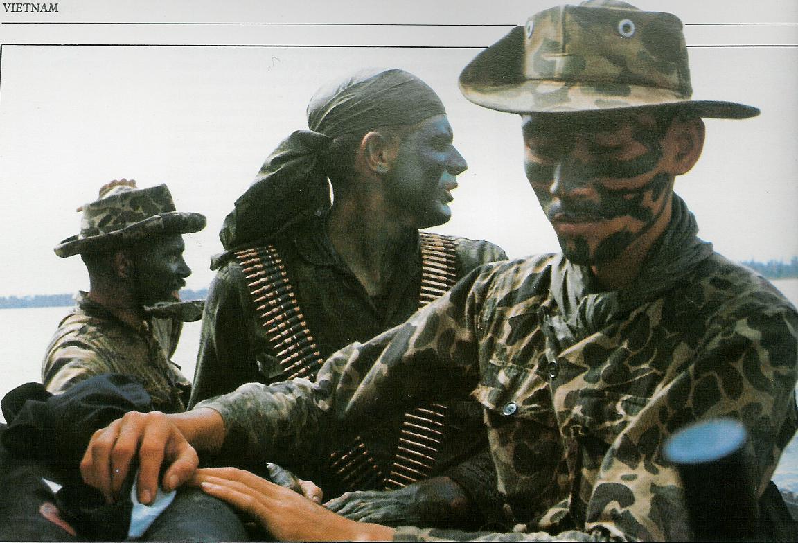 [SEALs] Camouflage clad SEAL team members aboard a riverine craft in
