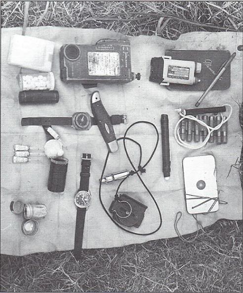 [SOG] <i>From book by MAJ John Plaster (Ret.) called SOG: A Photo History of the Secret Wars.</i>
Survival gear typically found in a recon man's pocket's included emergency radio, penflare, mirror, morphine, whistle, and compasses, show here laid out on a signal panel.
